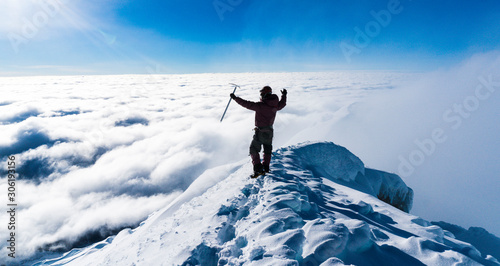 Alpinist in the summit of a mountain photo