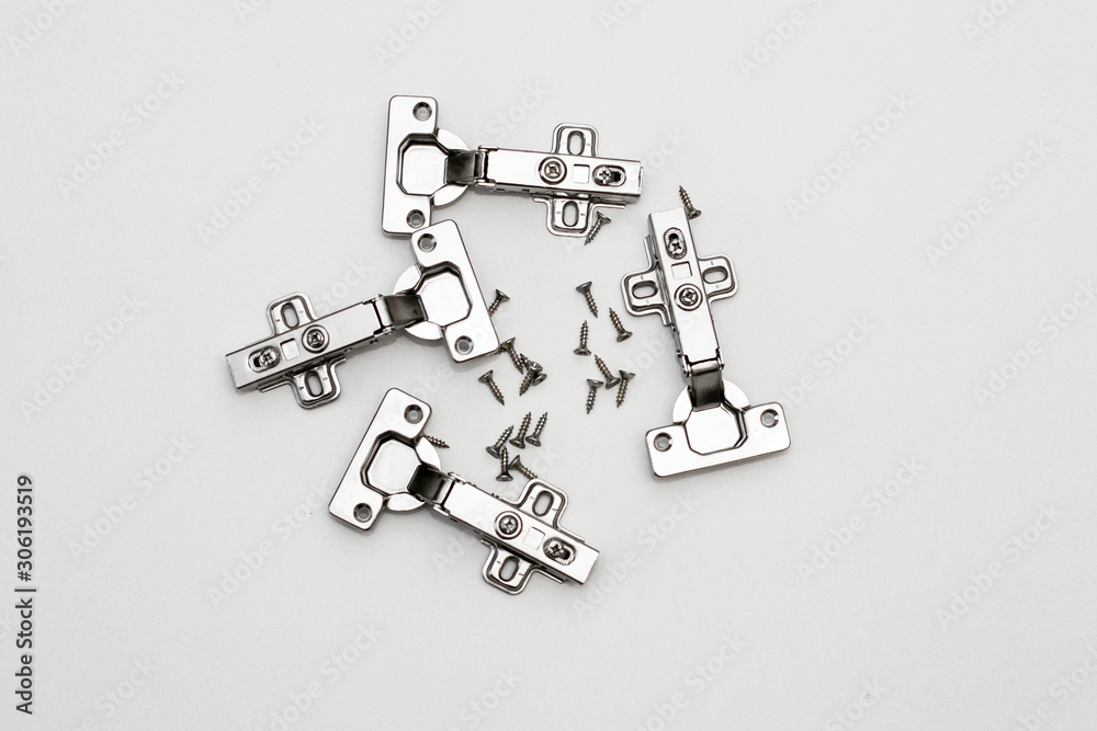 Fototapeta premium Four furniture awnings and screws on a white background. Steel furniture fittings.