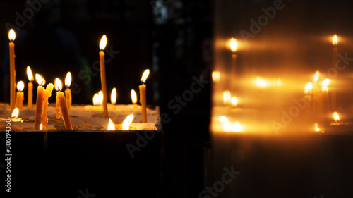 Candles Burning in a Church and Reflecting out of Wall