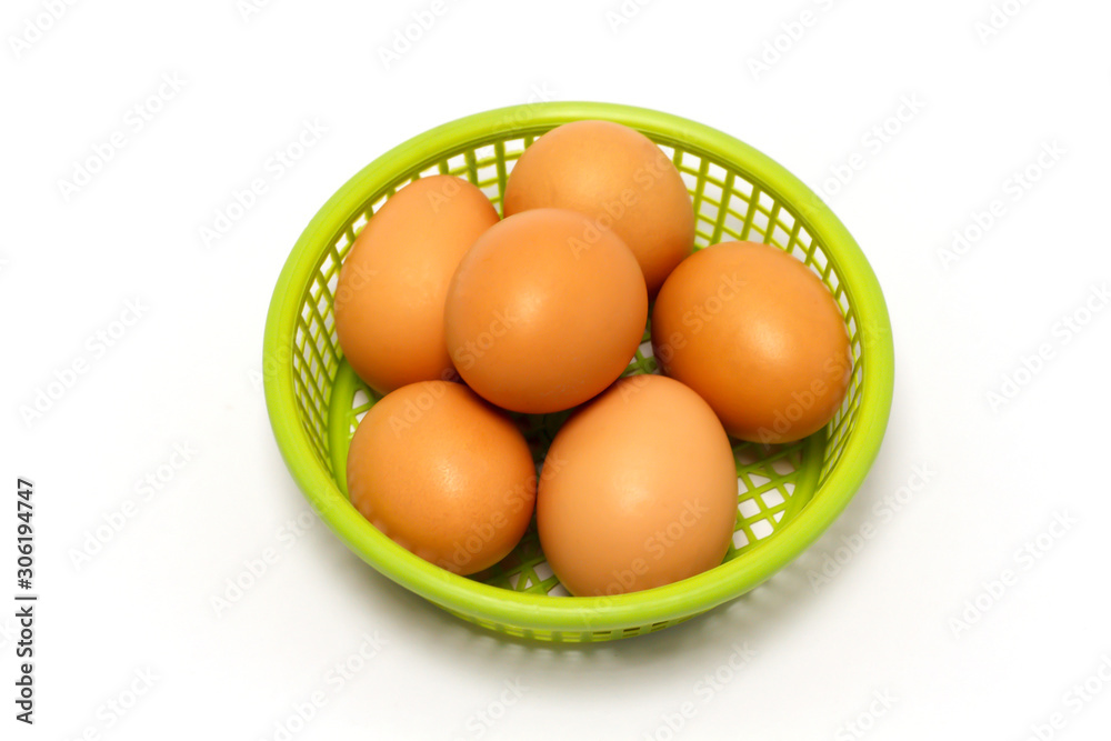 Chicken eggs are placed in a green basket. Chicken eggs are placed in a green basket.