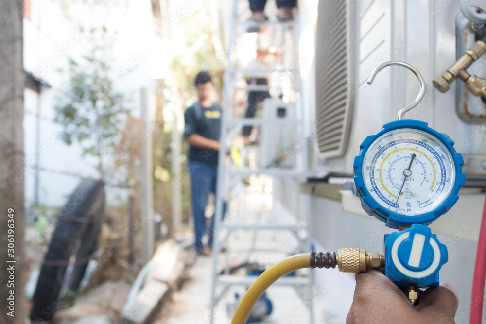 Technicians use manifold gauges to check the refrigerant pressure of air conditioners.