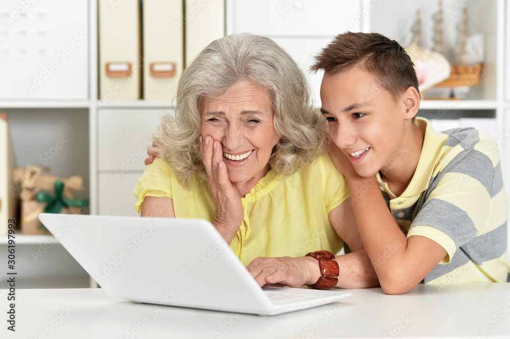 Portrait of grandmother with her grandson using laptop at home Portrait of grandmother with her grandson using laptop at home