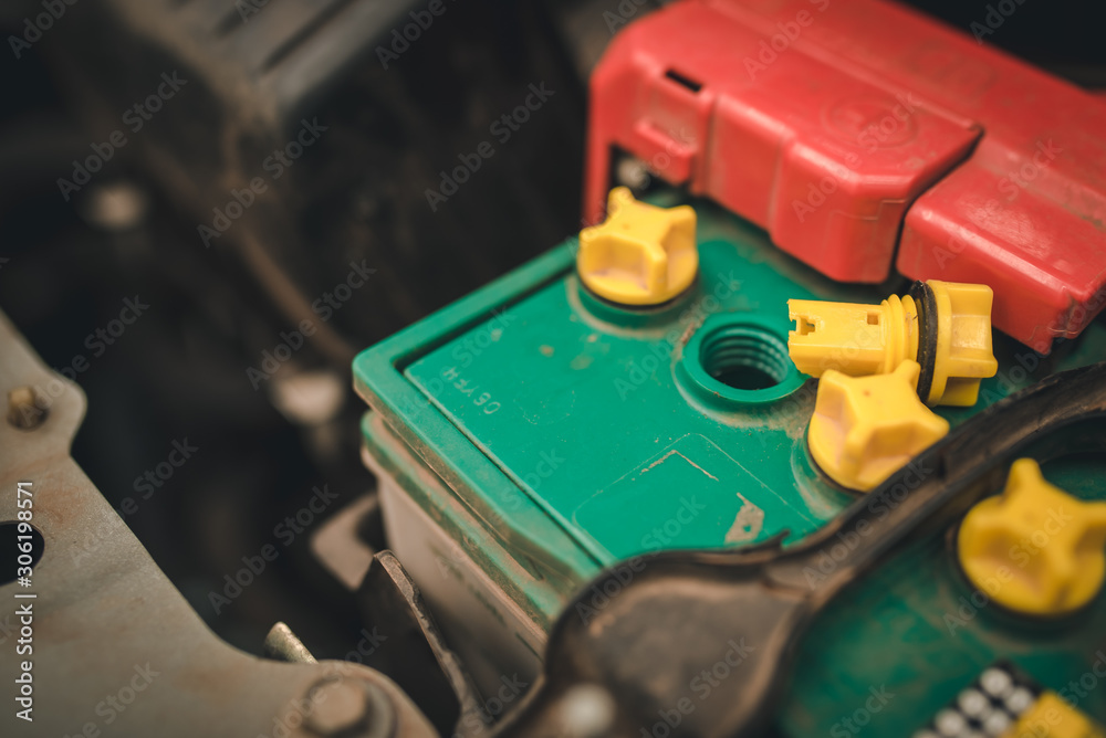 hand of Mechanic Check and Add water to car battery , selective focus auto mechanic uses to check and Maintenance car battery. hand of Mechanic Check and Add water to car battery , selective focus auto mechanic uses to check and Maintenance car battery.