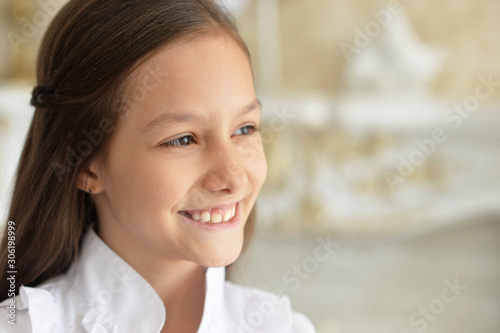 Close up portrait of emotional little girl in white blouse posing at home