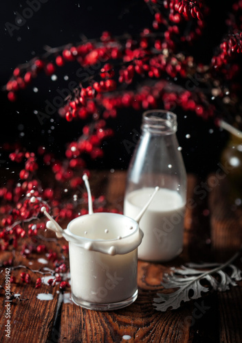 glass of milk with candle on red background