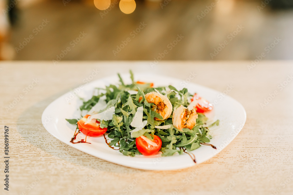 New Year 2020. Christmas table dinner time with salad decorated in New Year style on bokeh background. Christmas beautiful lights on gold warm background. New Year 2020. Christmas table dinner time with salad decorated in New Year style on bokeh background. Christmas beautiful lights on gold warm background.