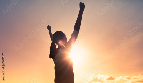 Strong, motivated woman with fist up to the sky. People feeling inspired and happy.  photo