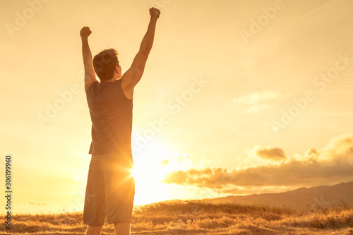 Strong, inspired and energized young fit man with arms up tot he sky. 