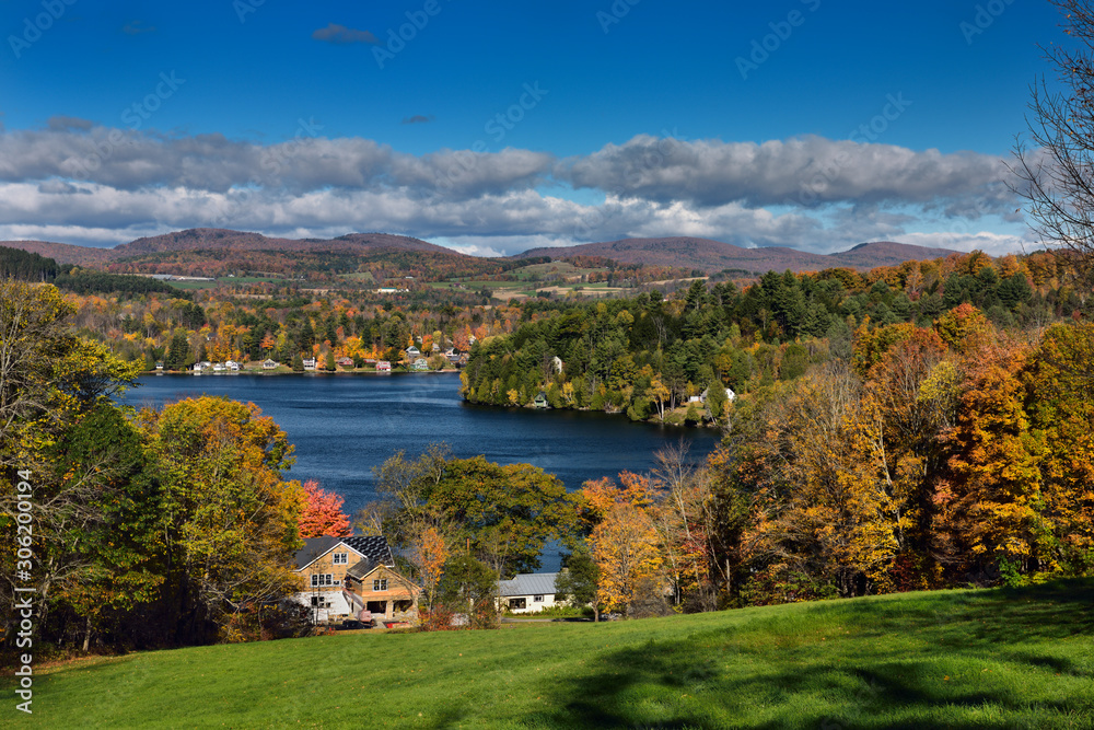 Cottages and houses on Harveys Lake West Barnet Vermont with trees in Fall color