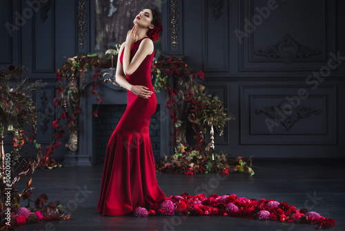 Fotografie, Tablou Attractive gorgeous brunette woman in red evening dress with plume in dark luxur