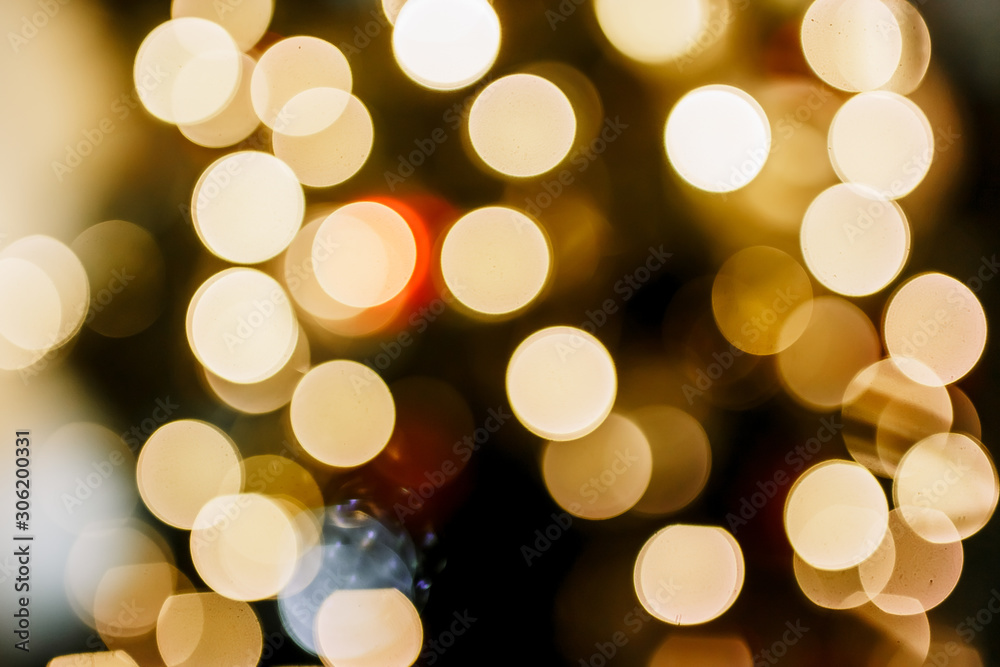New Year 2020. Christmas beautiful lights bokeh on gold warm background. Defocused Lights on a Tree Background. Christmas tree toys. Golden abstract blinking blurred. New Year 2020. Christmas beautiful lights bokeh on gold warm background. Defocused Lights on a Tree Background. Christmas tree toys. Golden abstract blinking blurred.