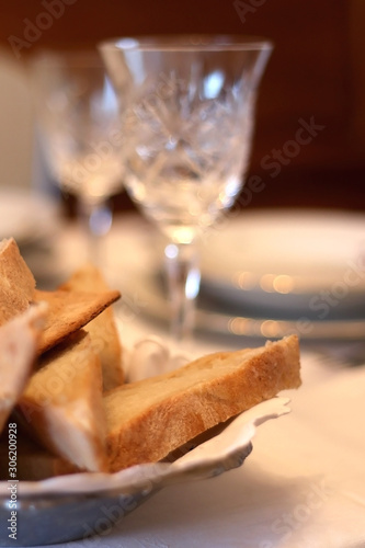Homemade bread and crystal glass on a holiday table. Selective focus.