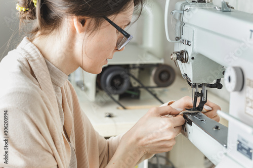 Fototapeta Naklejka Na Ścianę i Meble -  Woman stitching leather using a sewing machine