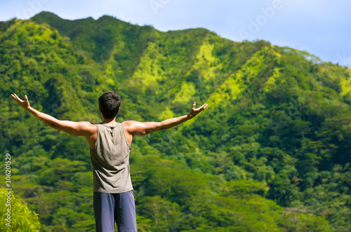 Enjoying nature getaway. Young man on a mountain breathing the fresh air. 