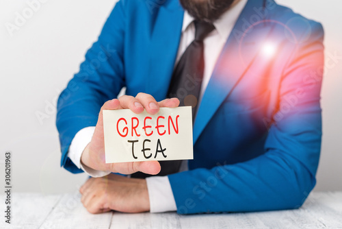 Word writing text Green Tea. Business photo showcasing type of tea that is made from Camellia sinensis leaves and buds Man holds empty paper with copy space in front of him Space photo