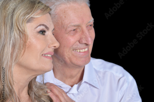 Close up portrait of happy senior couple posing on black background