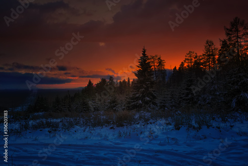 Colorful sunset in the winter forest. Beautiful winter landscape in the mountains. Sunrise.