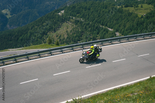 Bikers in mountain road in action ride, traveling across Europe, motorcycle tour, curve highway in mountains, copy space, extreme transport, active lifestyle vacation. Grossglockner pass