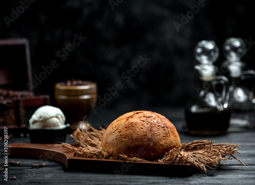 airy brown bread on a wooden board and a scoop of ice cream
