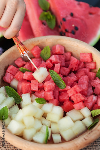 Plate of healthy summer fruit snack - with bites of melon and watermelon