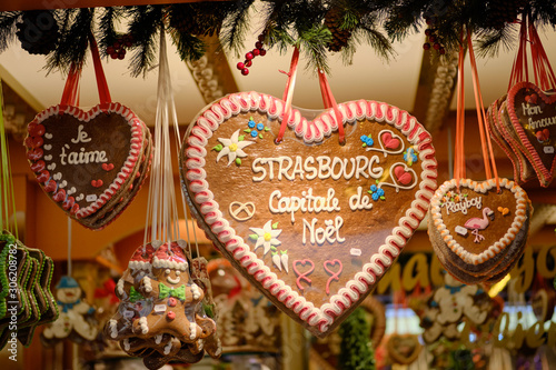 Gingerbread cookies in shape of hearts hanging from stall with messages of Christmas, Love and Strasbourg and a gingerbread man at the Strasbourg Christmas Market