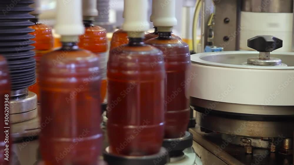 Beer in brown plastic bottles on the conveyor. Shop for bottling beer in a brewery. Beer in the brewery is bottled and labeled. Shop for bottling and packaging beer.