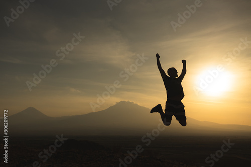 a man travels in Armenia, Yerevan. At sunset, she jumps silhouettes against the backdrop of Mount Ararat. Very beautiful landscape.