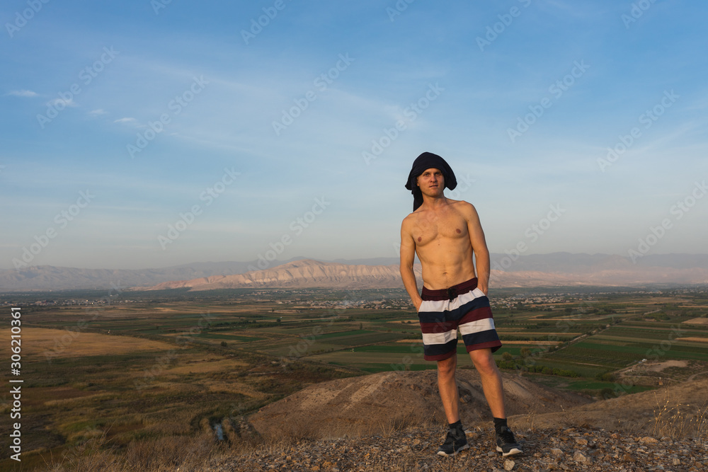 Fototapeta premium a man travels in Armenia, Yerevan. At sunset, she jumps silhouettes against the backdrop of Mount Ararat. Very beautiful landscape.