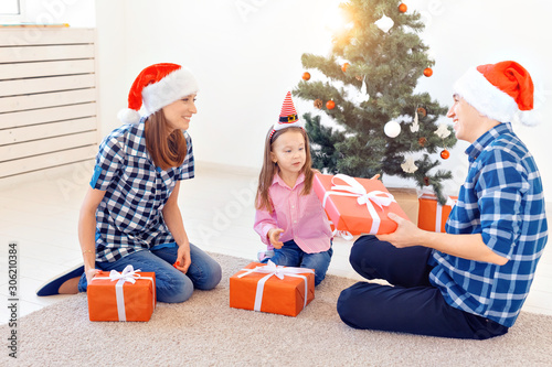 Holidays and presents concept - Portrait of a happy family opening gifts at Christmas time