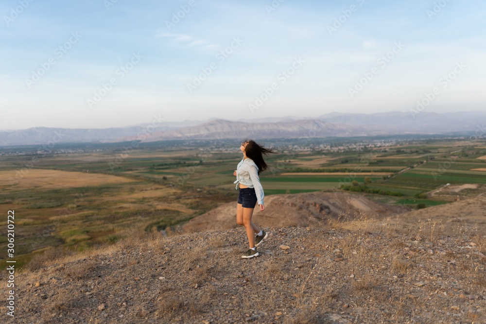 Beautiful and slender Girl travels in Armenia, Yerevan. At sunset, she jump silhouettes against the backdrop of Mount Ararat. Very beautiful landscape