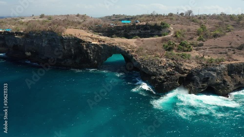 Natural Arch and Hole on Nusa Penida Island, Bali Indonesia, Aerial Pull Back. Broken Beach Pasih Uug photo