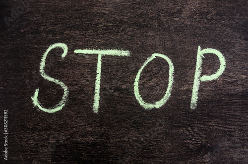 Colorful chalk drawing: the word STOP written in chalk on a black chalkboard.