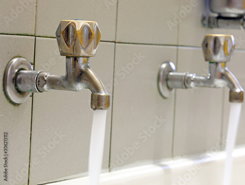 Fototapet taps in stainless steel on the washbasin with water