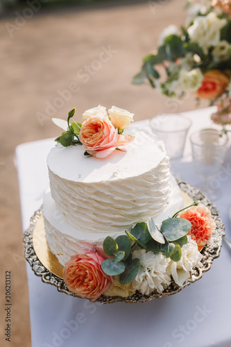 Wedding decoration table in the garden, floral arrangement, In the style vintage on outdoor.  Wedding cake with flowers. Decorated table with flowers, served for two people. Fine art background. © Anastasia