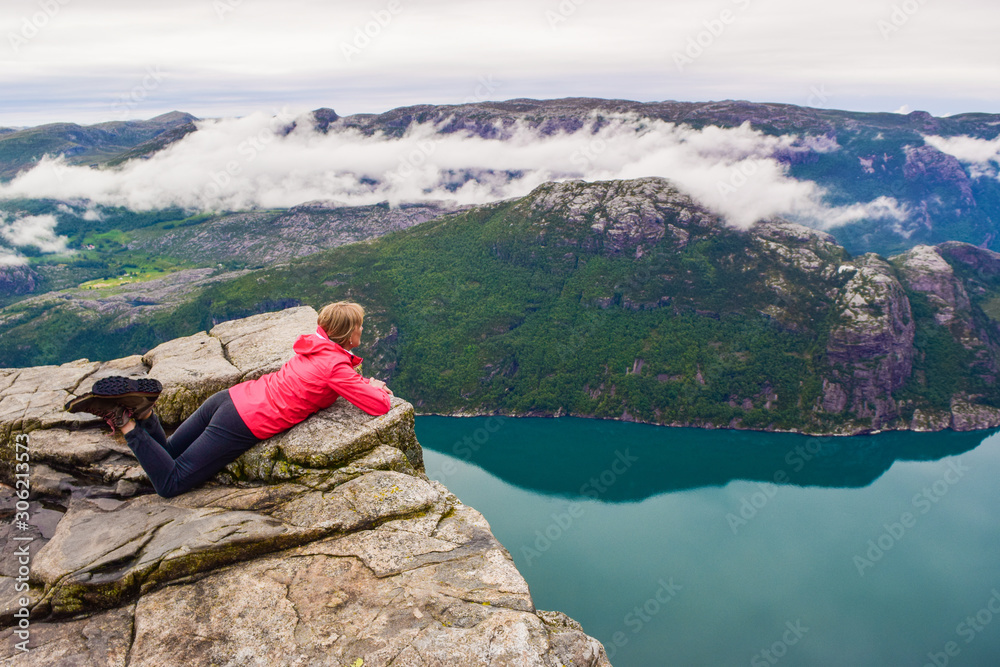 Naklejka premium Girl on Prekestolen or Pulpit Rock in the rain. Norway.