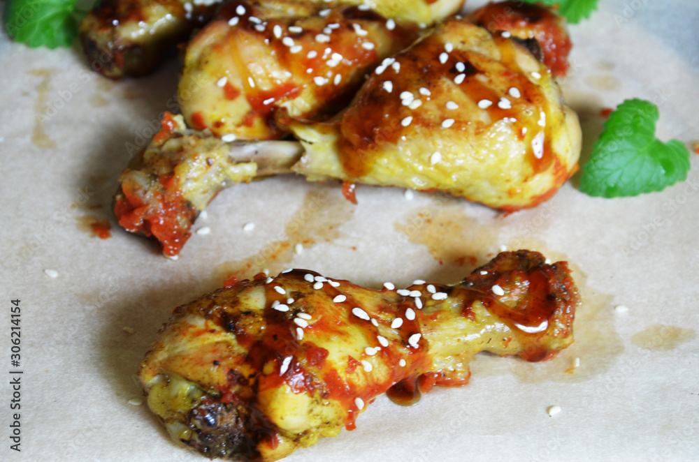 Grilled spicy chicken legs on a black background.Top view. backet chicken on paper Grilled spicy chicken legs on a black background.Top view. backet chicken on paper