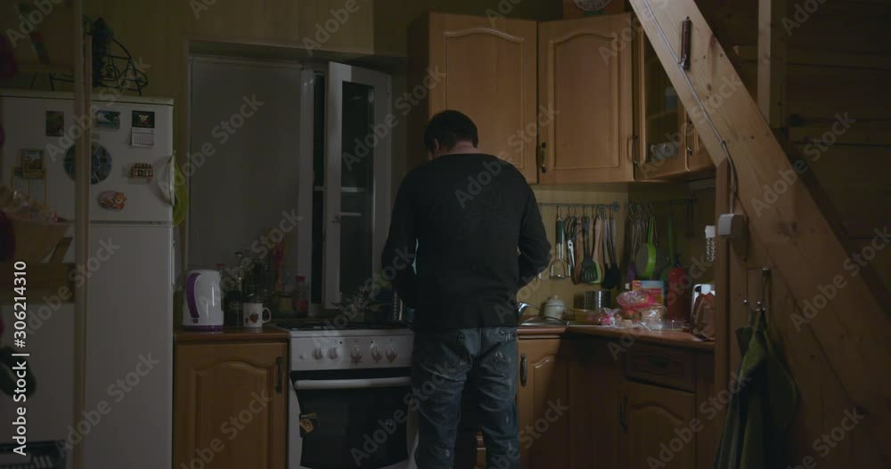 Depressed man prepares a sandwich in the kitchen and leaves