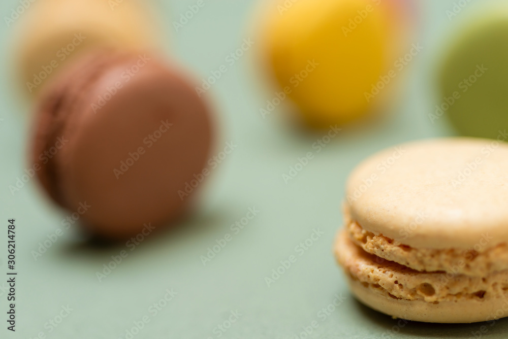 Obraz premium Colored tasty macaroons over a green background
