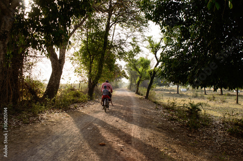 Indian villager going to buy some chocolate for his grand son on bicycle on summer days.