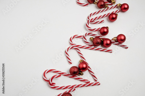 Christmas winter composition. Red balls with candy canes on white background. Top view, flat lay 