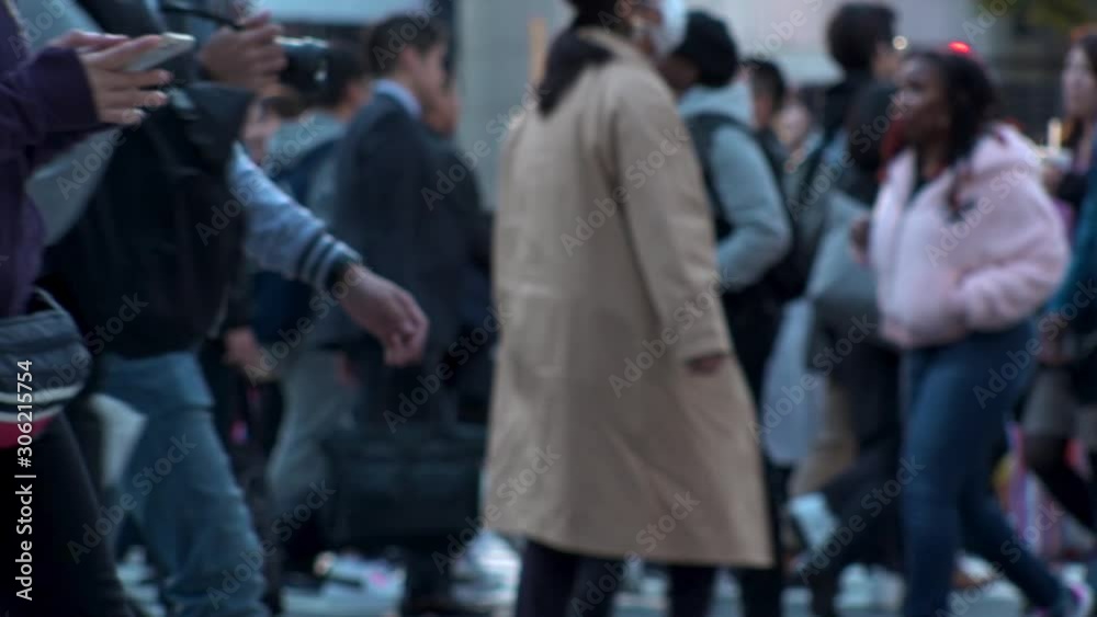 TOKYO, JAPAN - NOV 2019 : Crowd of people at Shibuya Scramble Crossing in busy early evening rush hour. Many commuters and tourists at the street. Shot in sunset time. In front focus. Slow motion. TOKYO, JAPAN - NOV 2019 : Crowd of people at Shibuya Scramble Crossing in busy early evening rush hour. Many commuters and tourists at the street. Shot in sunset time. In front focus. Slow motion.
