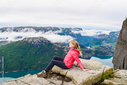 Girl on Prekestolen or Pulpit Rock in the rain. Norway.