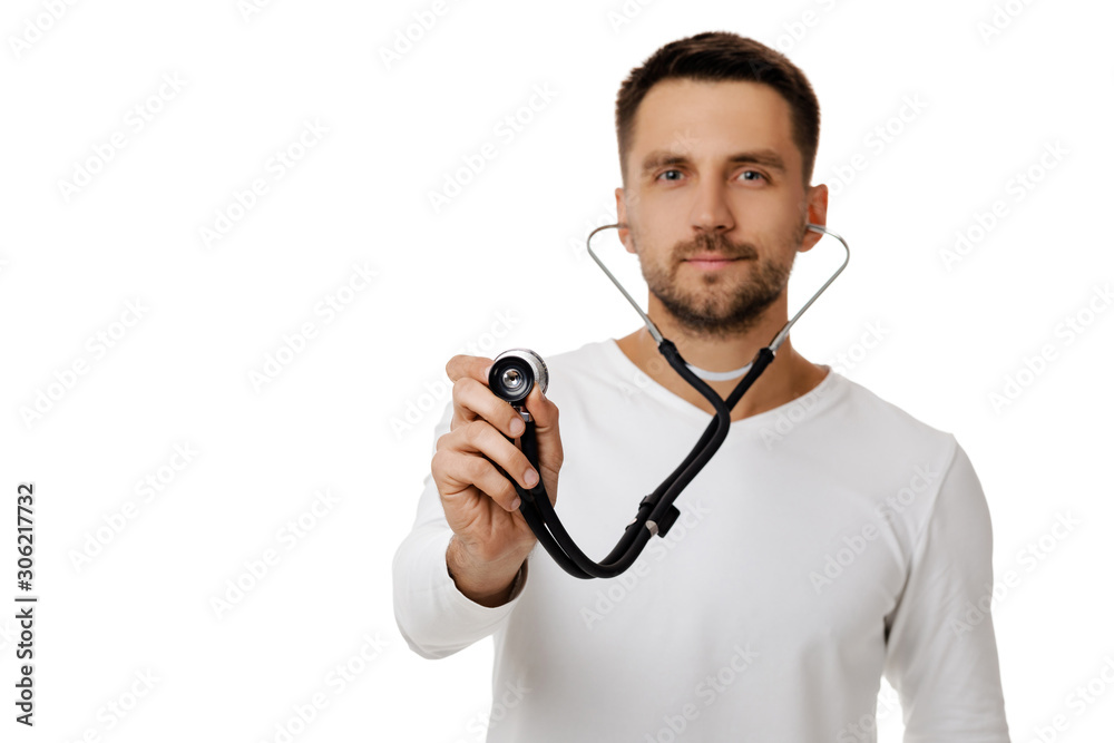 handsome man doctor holding stethoscope isolated on white. focus on stethoscope handsome man doctor holding stethoscope isolated on white. focus on stethoscope