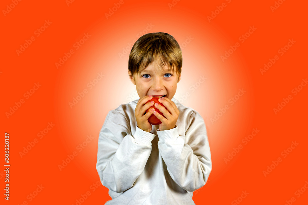 little girl eats fruit isolated on red background little girl eats fruit isolated on red background