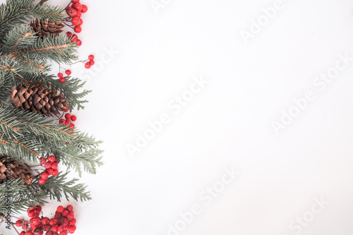 Christmas winter composition. Rowan, fir branches and cones on pink background. Top view, flat lay