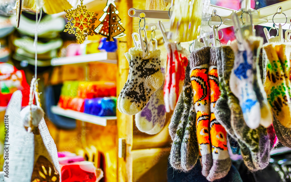 Colorful warm gloves and socks at the Christmas Market in Riga, Latvia. Clothes. Wool mittens on stalls in winter. Street Xmas and holiday fair in European town. Advent Decoration with Craft on Bazaar
