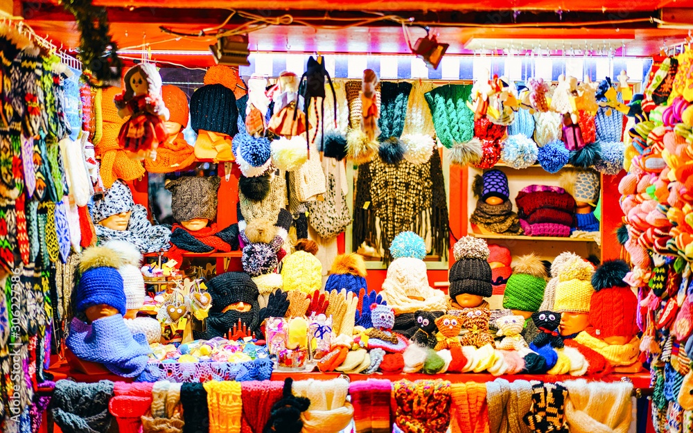 Knitted goods displayed on a Christmas market stall. Old Town of Riga, Latvia. Wool mittens, gloves, socks with hats in winter. Street Xmas and holiday fair in European city. Advent Crafts on Bazaar