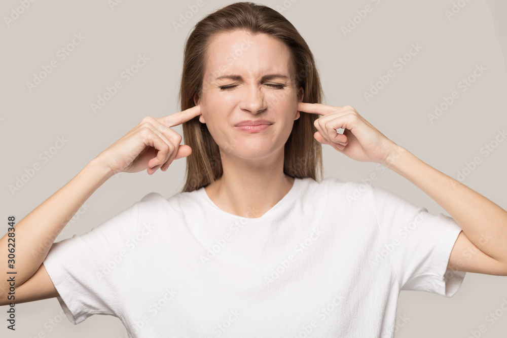Annoyed unhappy woman plug ears with fingers, avoid loud noise Annoyed unhappy woman plug ears with fingers, avoid loud noise