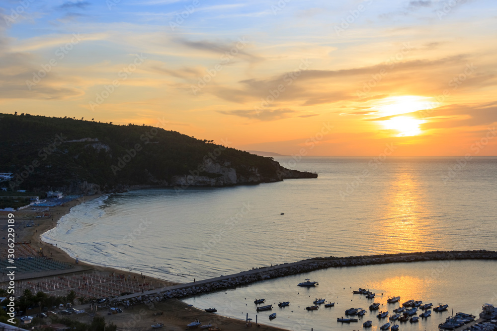 Panoramic view of the bay of Peschici at sunset: the marina and the sandy beach, Italy (Puglia). Peschici is famous for its seaside resorts, its territory belongs to the Gargano National Park.