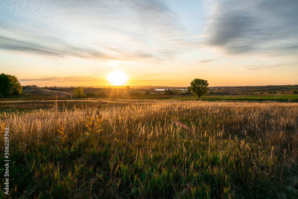 Golden sunrise over a meadow with far views Golden sunrise over a meadow with far views